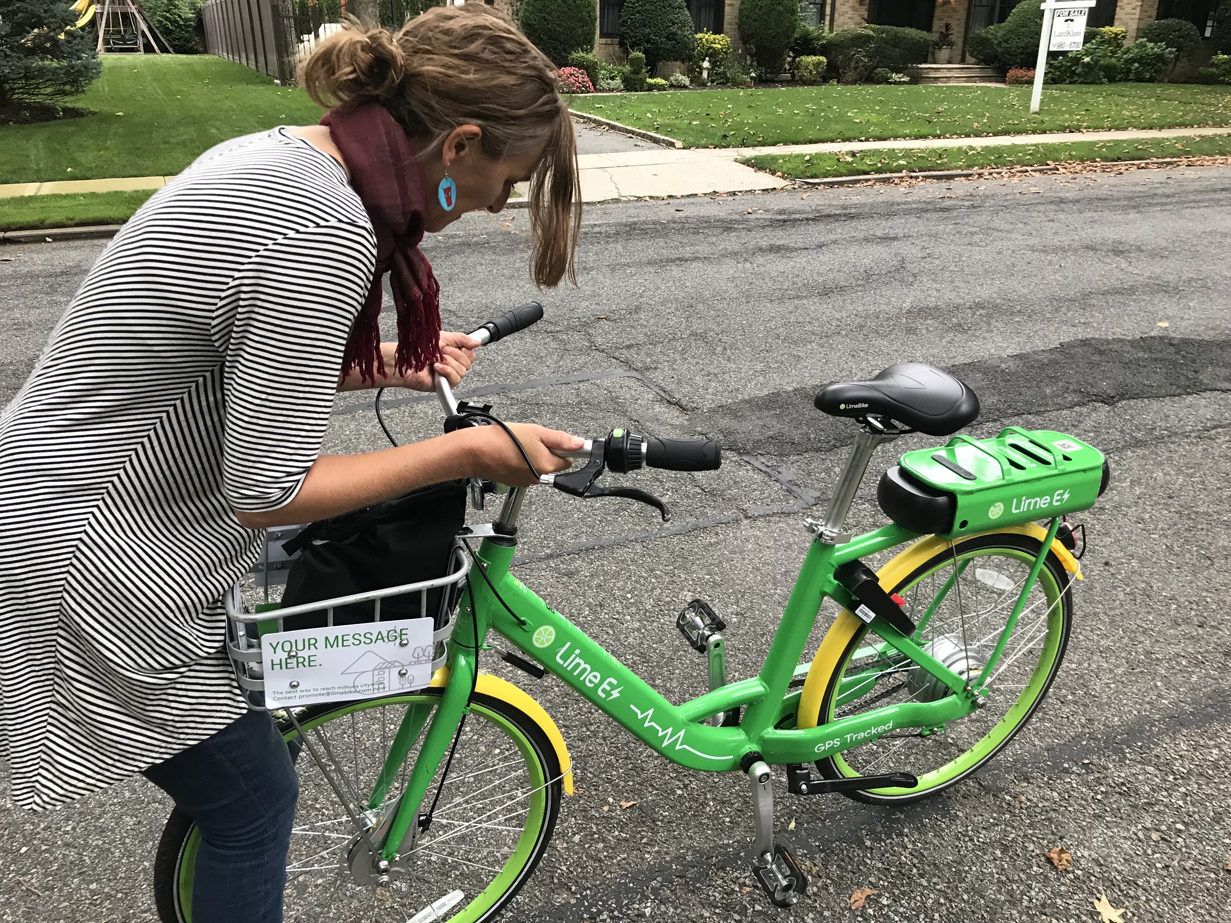 A Lime customer adjusts the handlebars of a misaligned bike. Photo: Gersh Kuntzman