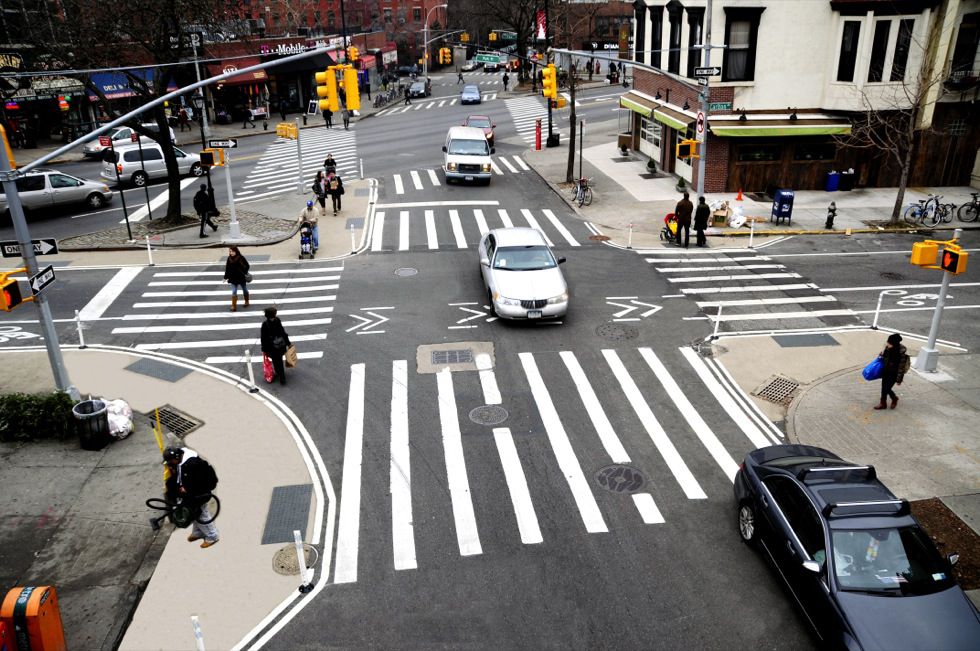 Curb extensions and neckdowns, like those shown in this NYC DOT picture, make roadways safer. Yet DOT says it needs a maintenance partner before it can build them.