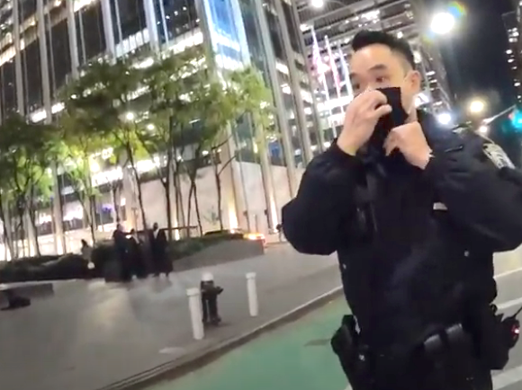 The officer dons a mask before approaching the illegally parked motorists.