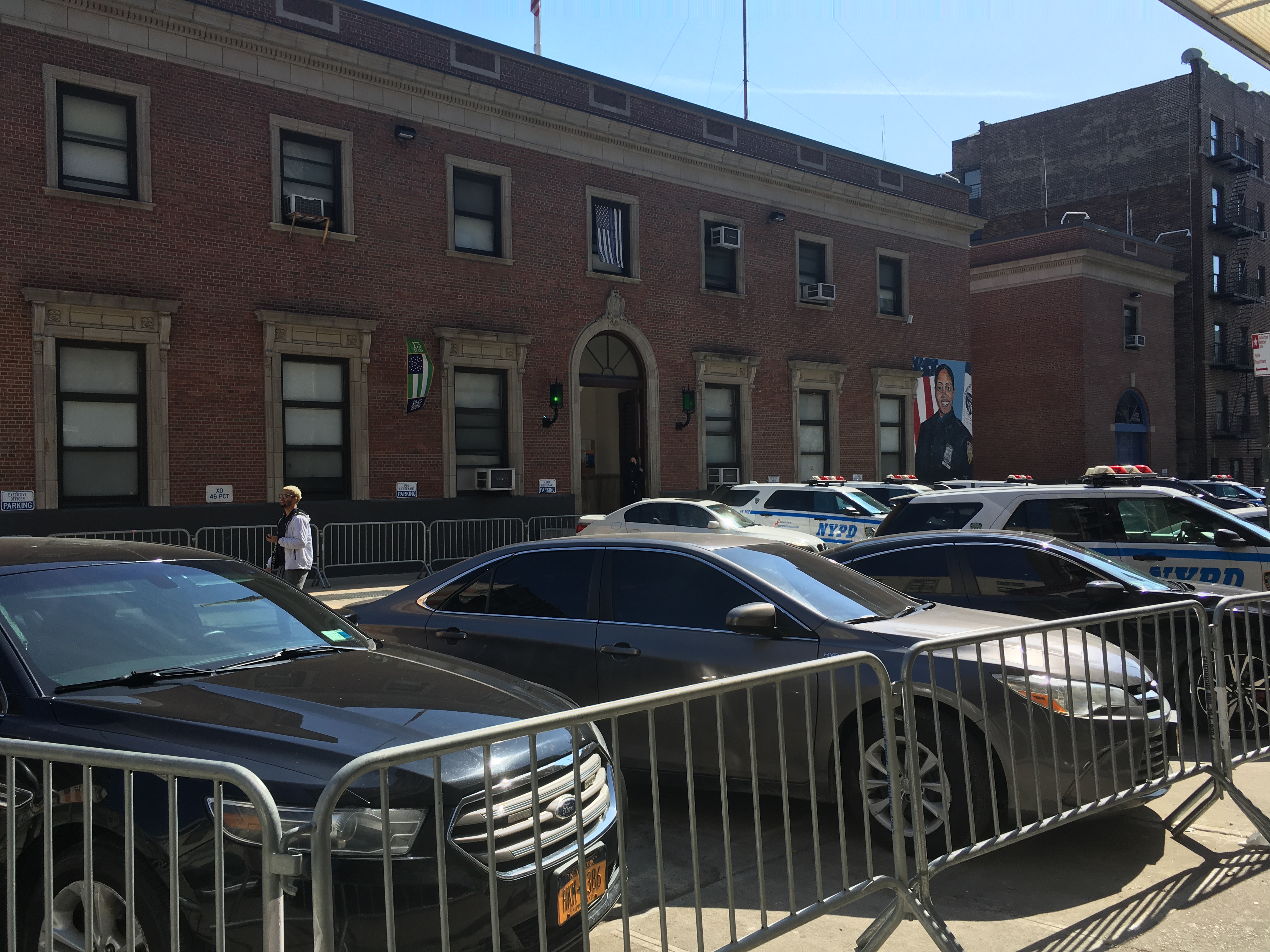 Ryer Avenue, looking east at the 46th Precinct. Cars line both sidewalk. Photo: Eve Kessler