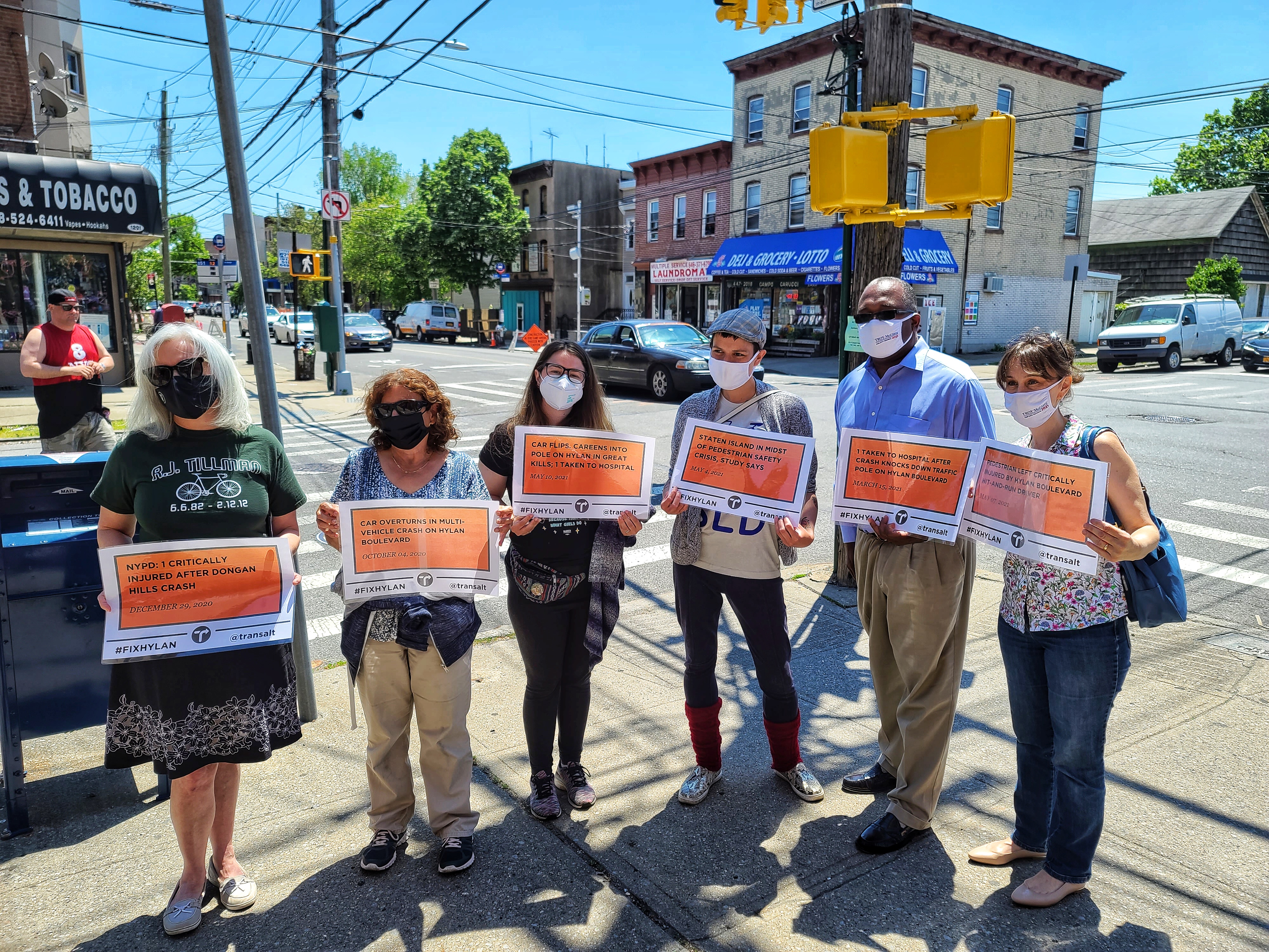 The activists are holding signs with headlines about various crashes on Hylan Boulevard.