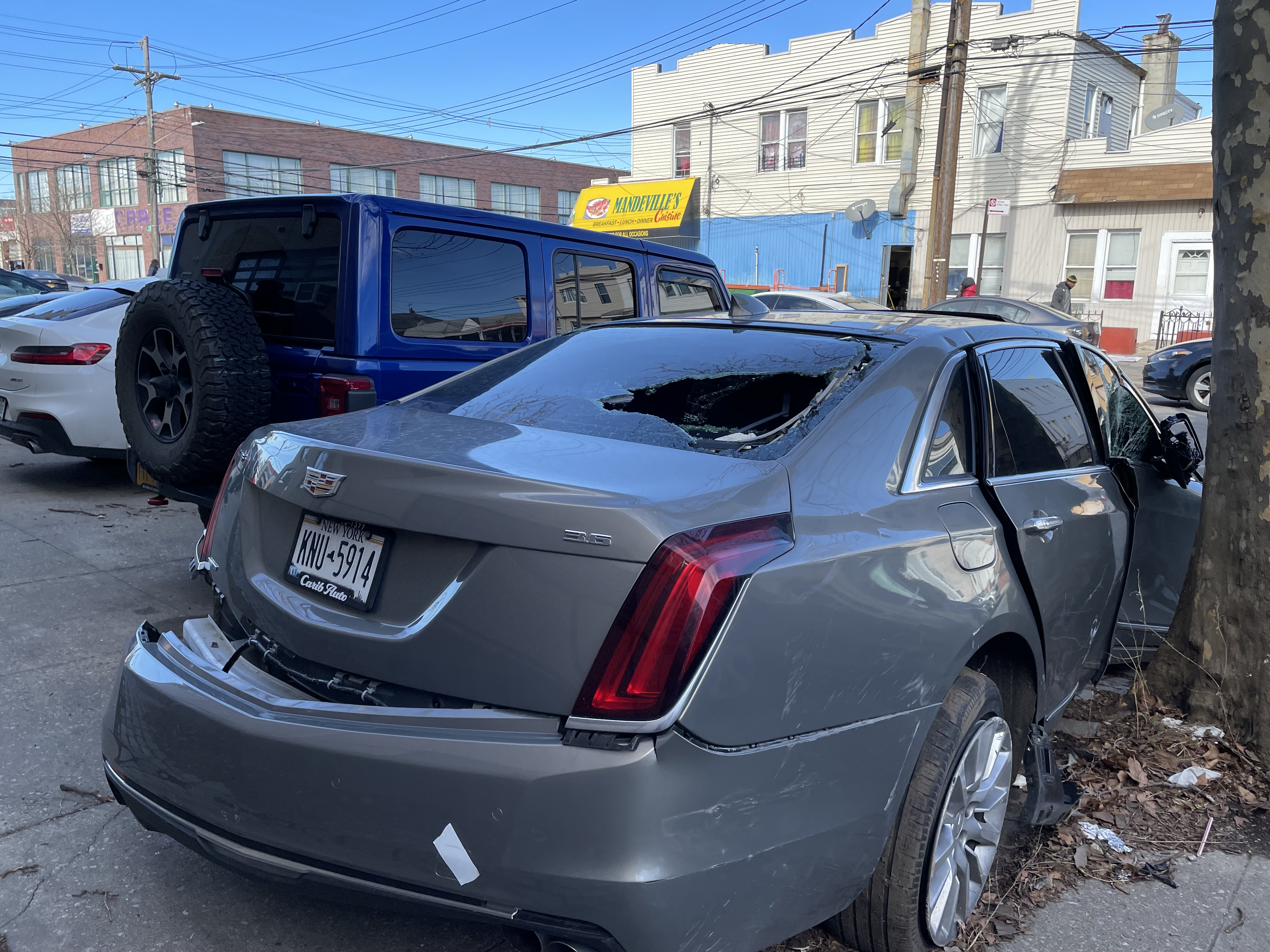 A junked car half on the sidewalk on East 98th Street. Photo: Dave Colon
