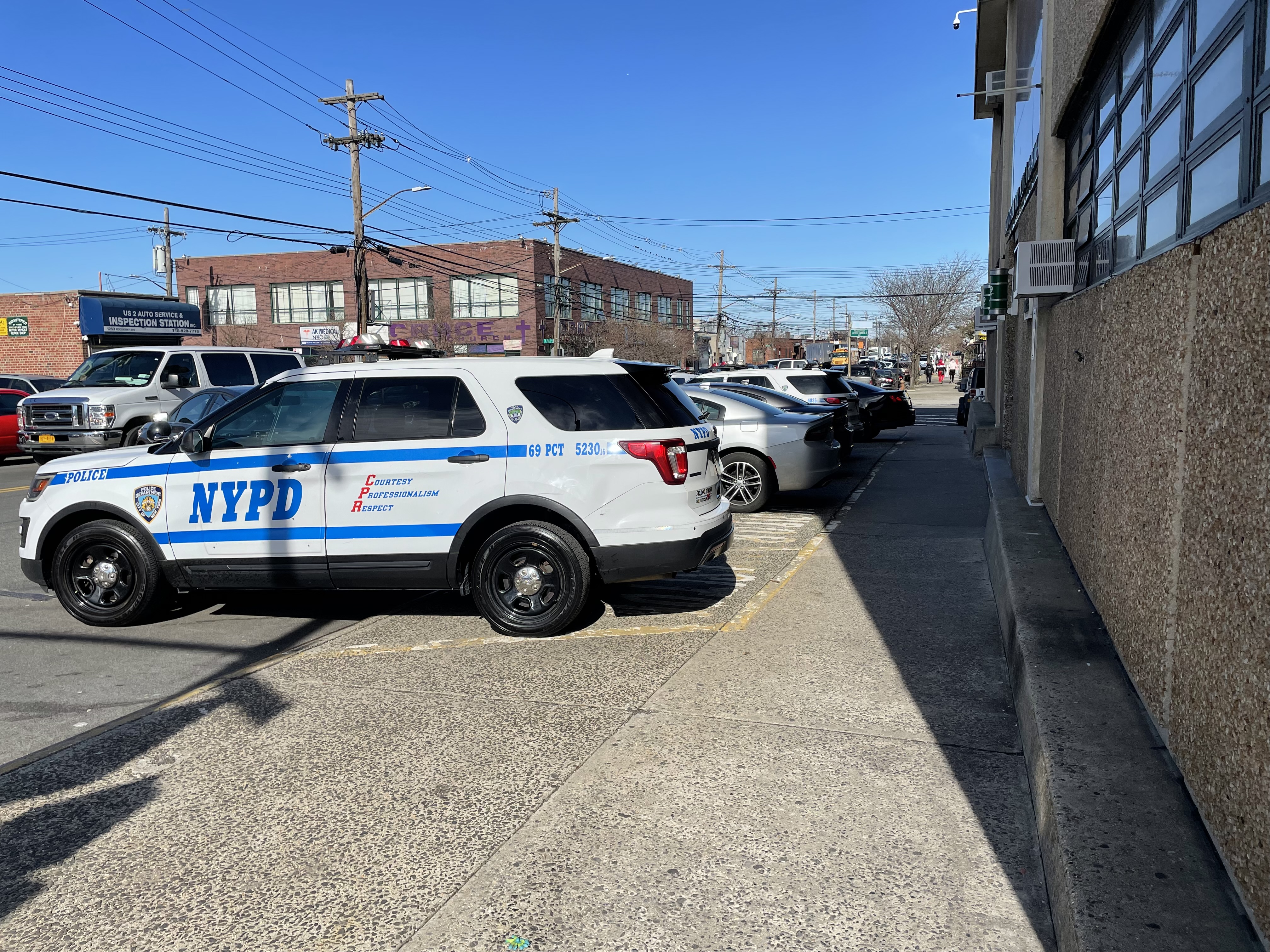 Cars parked on the sidewalk in front of the 69th Precinct on Foster Avenue. Photo: Dave Colon