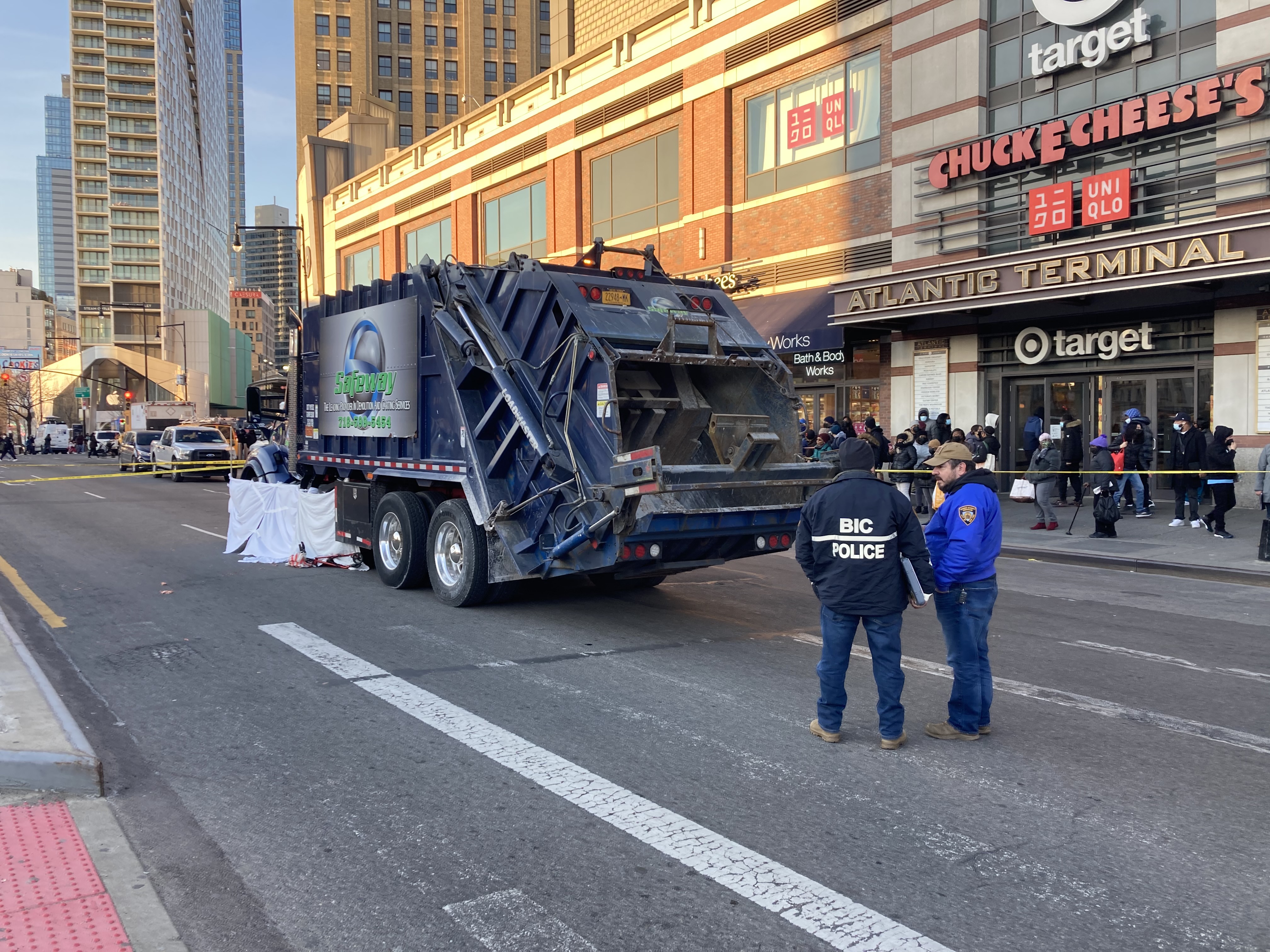 Police and a Business Integrity Commission staffer compare notes on the crash at Atlantic and Flatbush avenues. Photo: Julianne Cuba