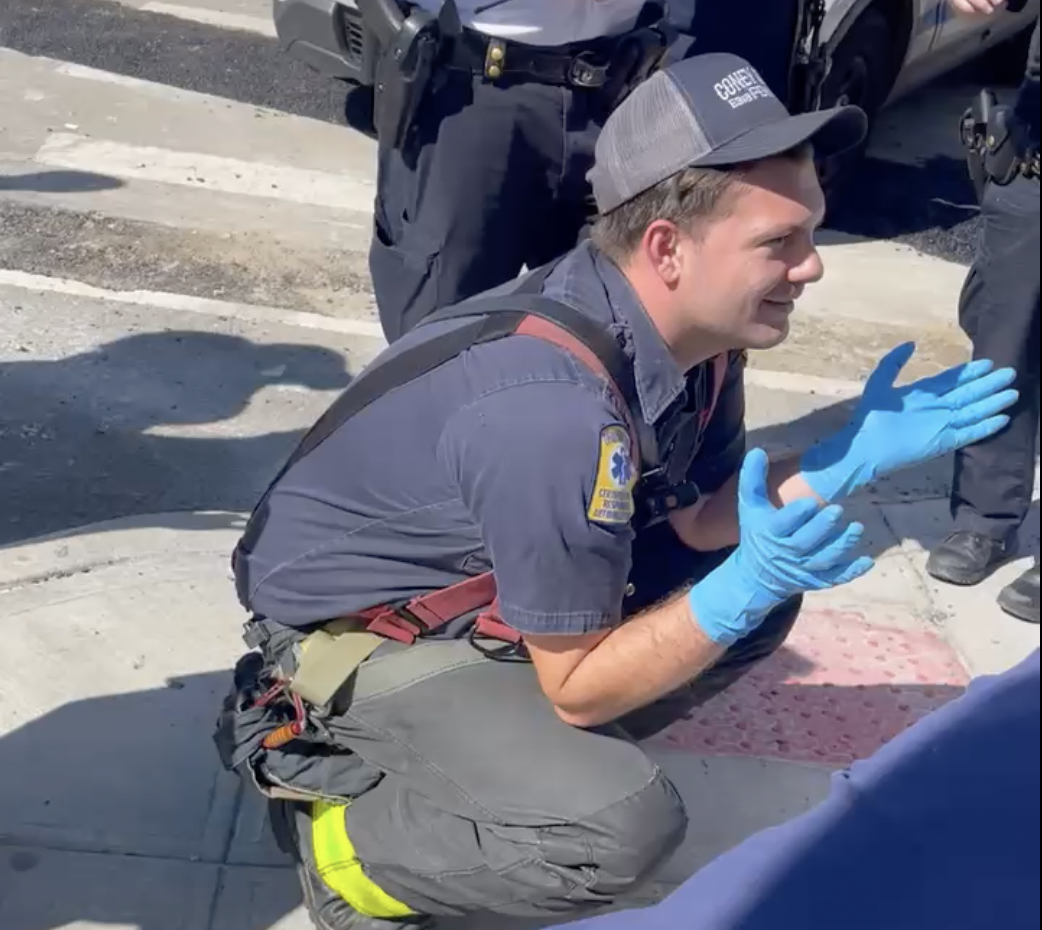 An EMT tries to encourage the boy to let him inspect the injury.
