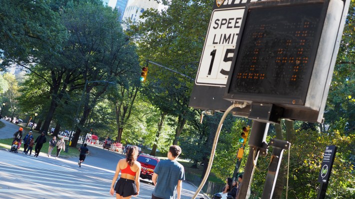 Two runners walk past a malfunctioning Central Park speed sign on Thursday, October 16. It shows them (or someone or something) doing 14 miles per hour.